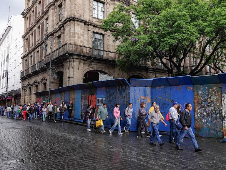Peatones realizan filas para poder ingresar al primer cuadro de la ciudad debido a las vallas metálicas colocadas para detener el acceso a los maestros pertenecientes a la CNTE