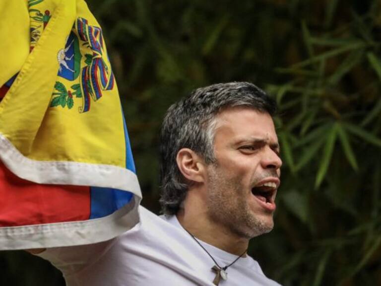 Leopoldo López se asoma con la bandera de Venezuela desde su casa