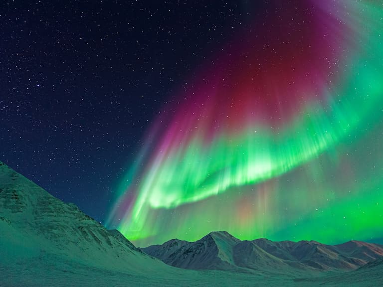 Gigantic Aurora borealis (Northern Lights) above mountains near Atigun Pass, Dalton Highway, Alaska, USA