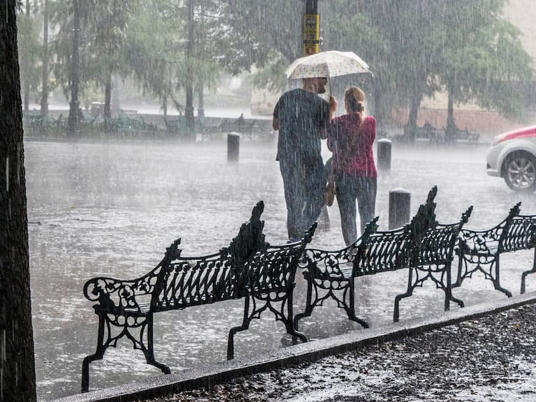 Una pareja camina bajo una fuerte lluvia en la zona centro de la Ciudad de México. Getty Images