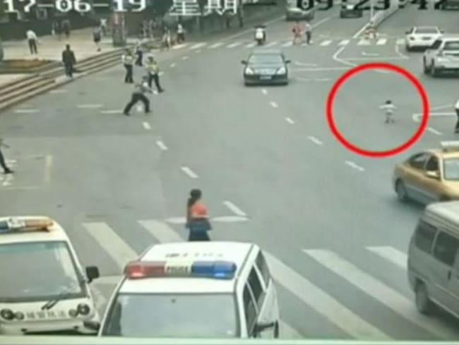Policía salva a niño de ser atropellado en China