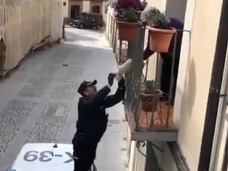 Policía trepa el balcón de una abuelita para darle su regalo de cumpleaños