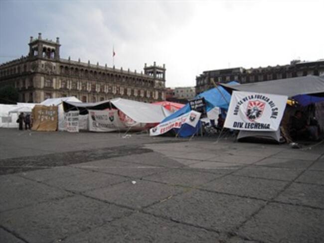 Choca mujer contra carpas en el Zócalo capitalino