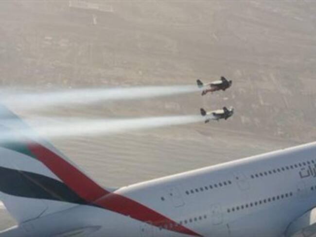 2 hombres con 'jetpacks' vuelan a metros de un avion