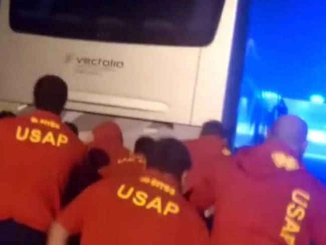 Jugadores de rugby empujan un autobús que se queda parado