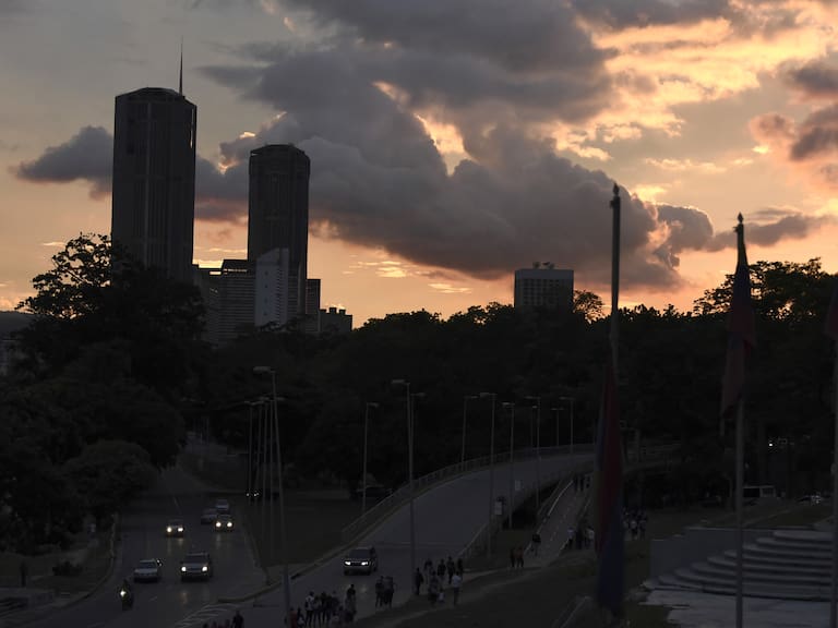 An electricity blackout in a city at dusk as vehicles travel on an unlit highway in Venezuela. Photographer: Carlos Becerra/Bloomberg