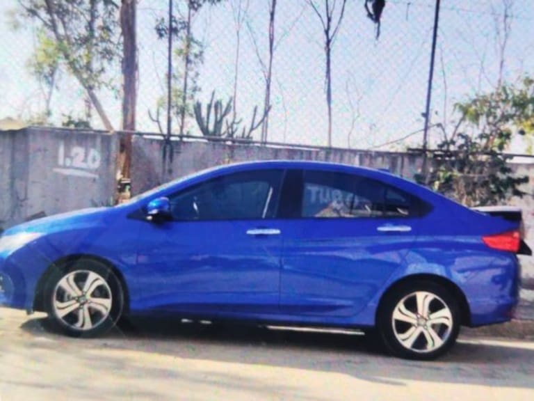 El auto es de color azul metálico de la marca Honda.