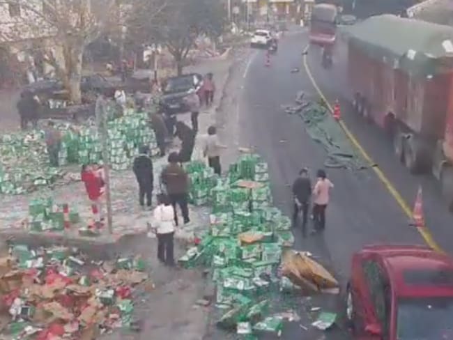 Camión vuelca en China y derrama bebidas; aldeanos se organizan para controlar la situación | VIDEO