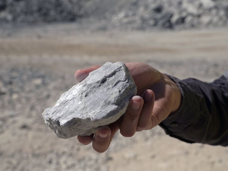 A person holding a lithium rich rock. Photographer: Carla Gottgens/Bloomberg