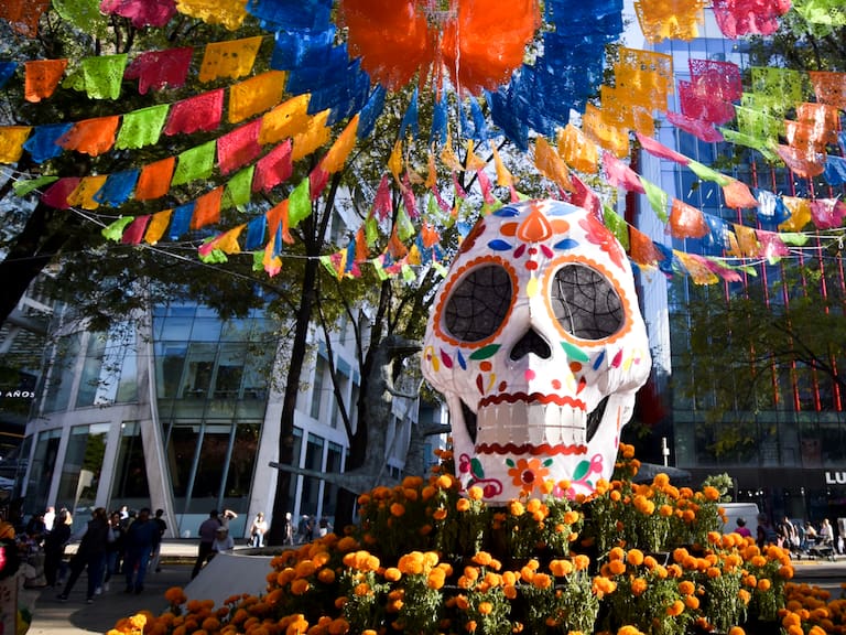 Una calavera monumental rodeada de flores de cempasúchil forma parte de los elementos tradicionales que acompañan las festividades de Día de Muertos en la Ciudad de México.