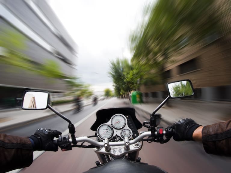Young man drives his moto through street, Granada, Andalucia.