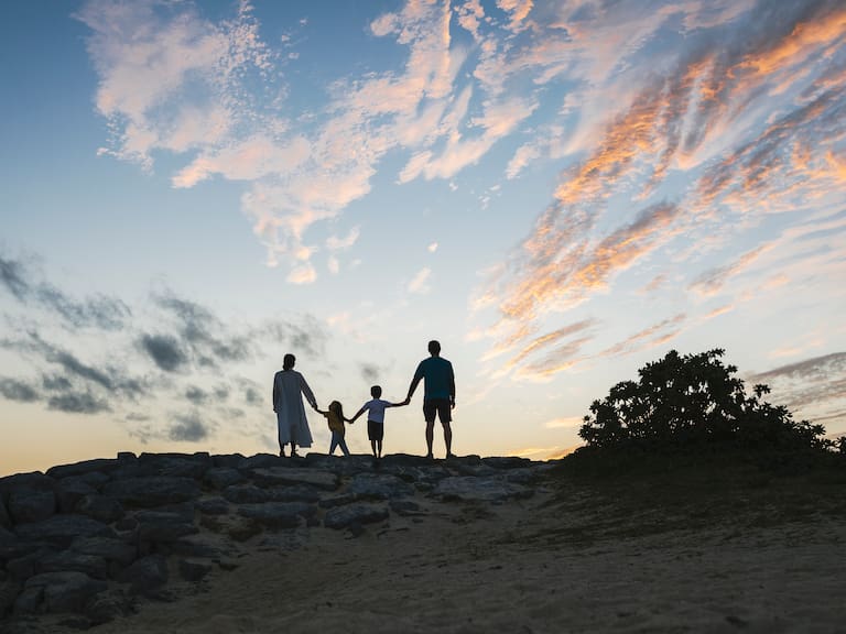 Family relaxed in the beach at dusk