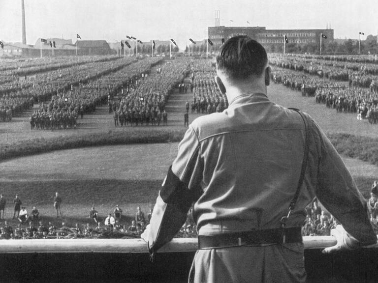 Adolf Hitler se dirige a los soldados de espaldas a la cámara durante un mitin nazi en Dortmund, Alemania.