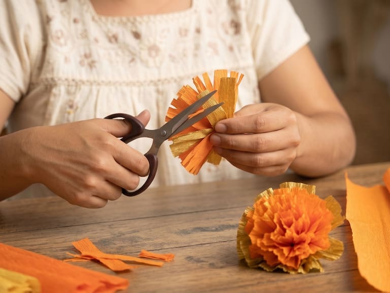 Las flores de cempasúchil de papel crepé son una alternativa económica y fácil de elaborar para decorar una ofrenda de Día de Muertos.