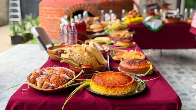 Mesa con tamales, pan de elote, postres y otros alimentos elaborados con maíz durante la Feria del Elote y la Tortilla en San Juan Ixtayopan, Tláhuac.