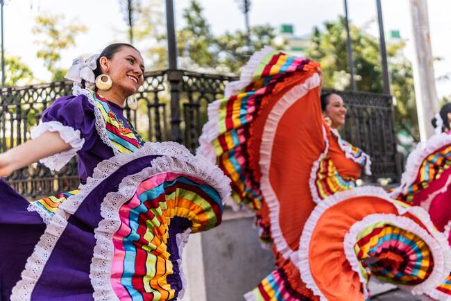 Mujeres con vestuario colorido, bailando